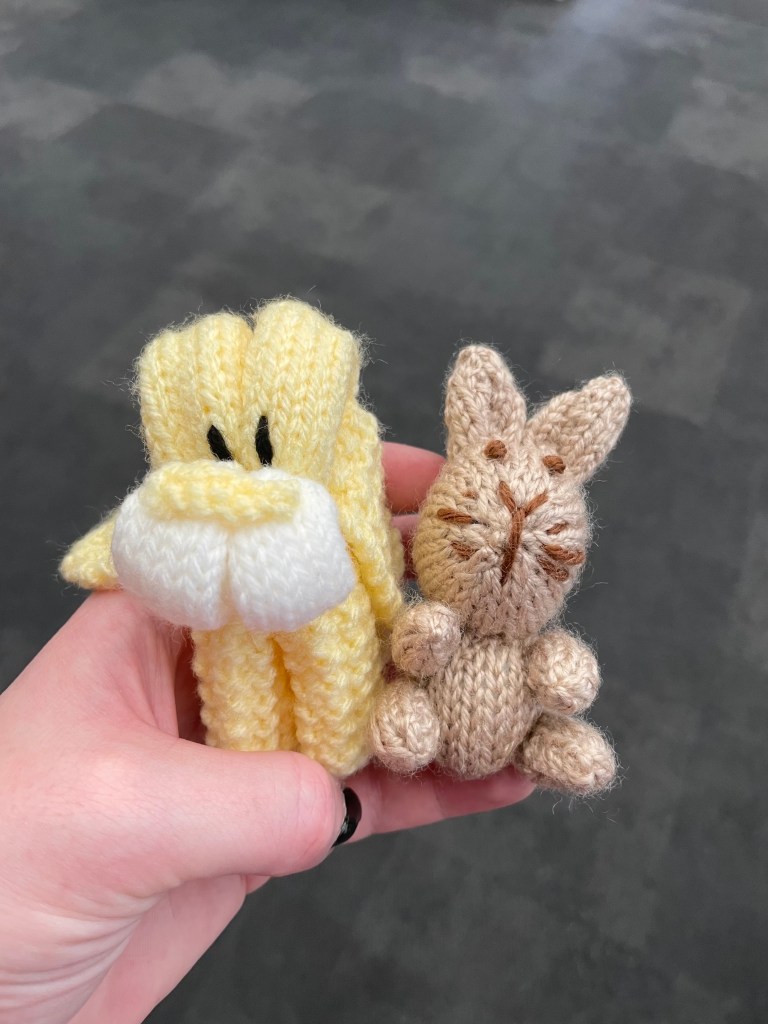 Crocheted animals - a friendly yellow lion and a brown bunny, held in a woman's hand